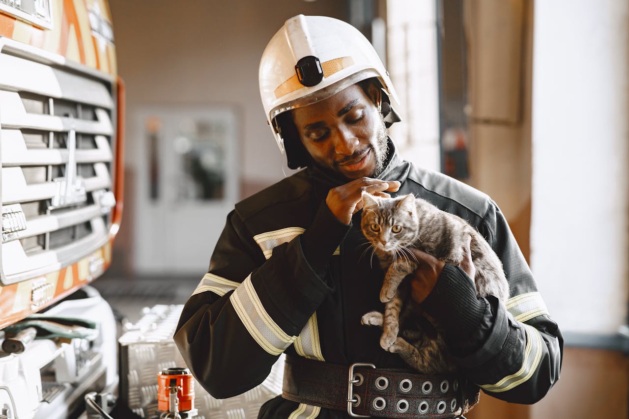 about-02 Firefighter in uniform caring for a rescued cat indoors. Professional and compassionate service.
